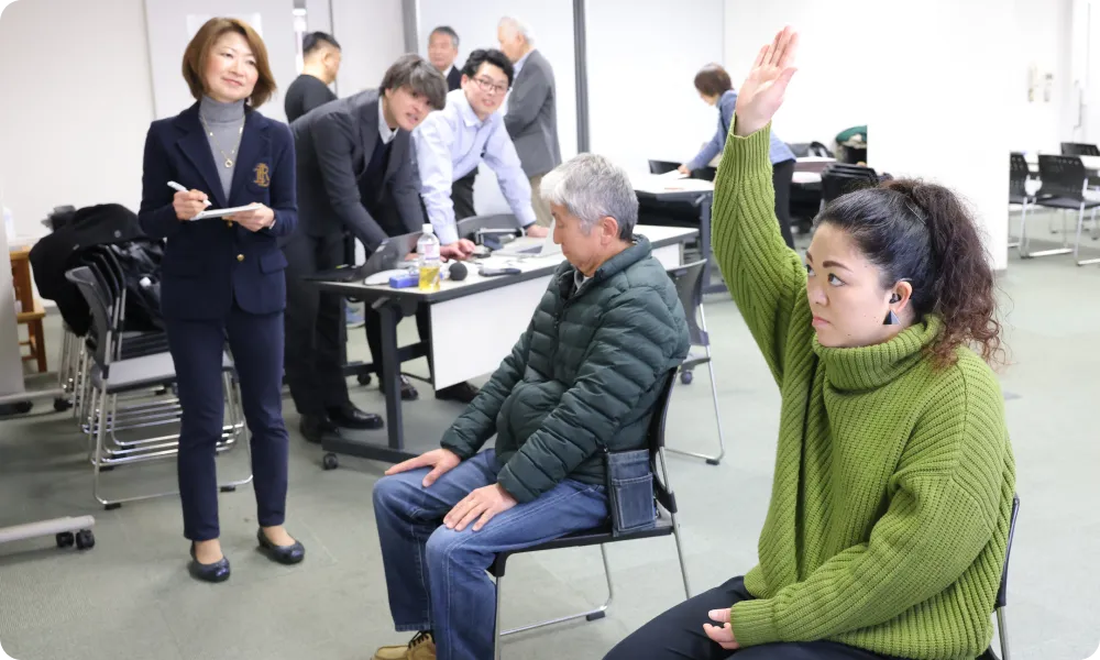 手を挙げる女性の画像